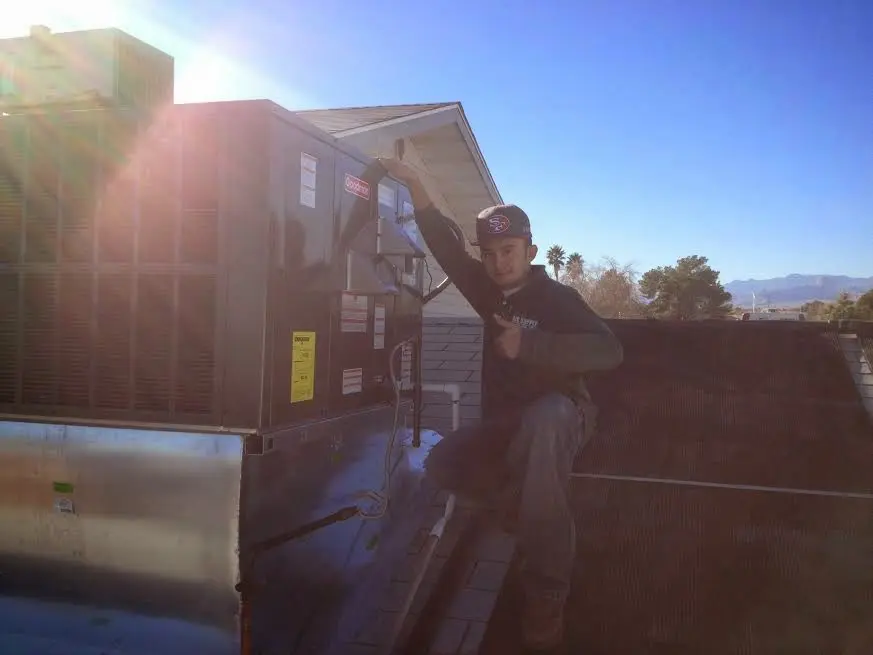 HVAC technician performing Boiler Repair on a rooftop unit in Veneta